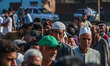 Voters queue to cast their ballots at a polling station during the third and final phase o...