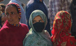 Women voters queue to cast their ballots at a polling station during the third and final p...