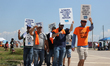 Dockworkers and their supporters hold signs during a strike outside the Bayport Container...