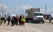 A passing semi-truck honks in a show of support during a dockworker strike outside the Bay...