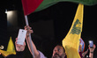 An Iranian man waves a Palestinian flag while celebrating Iran's missile attack against Is...