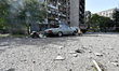 A car parks outside the residential high-rise damaged by Russian shelling in Zaporizhzhia,...