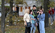 A police officer stands next to women who suffer from Russian shelling in Zaporizhzhia, Uk...