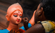 Artisans work on finishing touches of Goddess Durga idols at a workshop in the potter's co...
