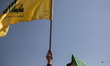 An Iranian man waves a flag of Lebanon's Hezbollah while taking part in a gathering markin...