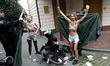 (EDITORS NOTE: Image contains nudity and profanity.) Barechested Femen activists, with slo...
