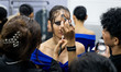 Models wear creations by POEM and get ready backstage before walking on the runway during...