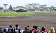 A number of residents watch aircraft landing during the TNI Transport Aircraft Static Show...