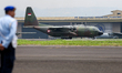 A soldier watches a plane land during the TNI Transport Aircraft Static Show event to comm...