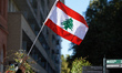 A woman waves the Lebanese flag during the protest. Hundreds of people demonstrate in Toul...