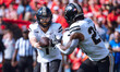 Purdue quarterback Hudson Card #1 pitches the ball to running back Reggie Love III #23 aga...