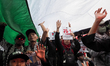Pro-Palestinian demonstrators unfurl Palestinian flags during a protest marking the one-ye...