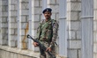 An Indian paramilitary soldier guards outside a vote counting center for the local assembl...