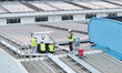 Technicians check photovoltaic power generation equipment before it is connected to the gr...