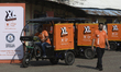 Swiggy gig workers ride electric three-wheelers during a promotional event in Mumbai, Indi...