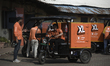 Swiggy gig workers ride electric three-wheelers during a promotional event in Mumbai, Indi...