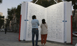 Two people observe a public art installation representing a monumental-sized dictionary in...