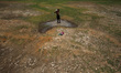 A village boy baths in the remaining water of a dried pond to beat the heat in today’s hot...