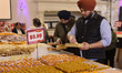 People purchase traditional Indian sweets at a sweet shop for the upcoming festival of Diw...