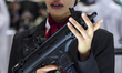 A visitor looks through the sights of a shotgun being demonstrated at the 15th edition of...