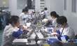 Employees process medical endoscope lenses at the production workshop of Hangzhou HAoke Op...