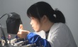 An employee processes medical endoscope lenses at the production workshop of Hangzhou HAok...