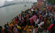 A Hindu devotee offers prayers to the sun god during the Chhath Festival at the Ganga ghat...
