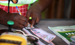 An INEC official signs a ballot paper during the 2024 Governorship election for Ondo State...