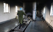 Tumpa Das, age 29, prepares a dead body for cremation in a furnace inside a crematorium in...