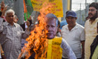 Protestors burn an effigy of Muhammad Yunus during a protest organized by South Kolkata Di...