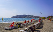 Tourists relax on beach loungers on the beach of the Mediterranean Sea in Alanya, Turkey,...