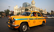 An iconic yellow Ambassador taxi crosses the road junctions in Kolkata, India, on December...