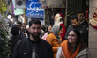 A young Iranian woman smiles as she looks at a statue of Santa Claus while Christmas shopp...