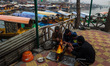 People warm themselves by a bonfire on a cold winter morning at Dal Lake in Srinagar, Jamm...