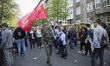 Naydencho from Bulgaria walks wearing a soldier uniform and carrying a flag of the Soviet...