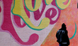 A person walks past a mural at the Innovation District transit station in downtown Brampto...