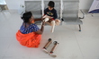 Nandani Dulai, a seven-year-old amputee, receives help from her mother inside the Rehabili...