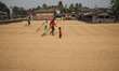 Workers spread rice for drying at a rice mill on the outskirts of Kolkata, India, on Decem...