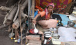A Sadhu or a Hindu holy woman prepares food at a makeshift shelter before heading for an a...