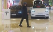 Customers walk past a Tesla outlet at a shopping mall in Hangzhou, China, on January 8, 20...