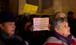 A woman holds a placard that says, ''Listen to all the girls and boys who suffer abuse,''...