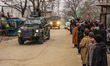 Kashmiri children watch as Indian army soldiers leave the site after an encounter breaks o...