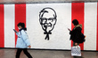 Pedestrians pass a newly opened KFC outlet in a subway in Shanghai, China, on January 14,...