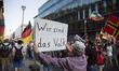 A protester holds a banner reading 'we are the people' during a march organised from right...