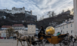 Tourists take a horse-drawn carriage ride through the old town of Salzburg in Salzburg, Au...