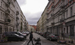 A man pushes a stroller as he crosses a road in the residential area of Prenzlauer Berg in...