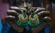 Mantu, 41, a goldsmith, shows gold earrings at a jewelry workshop in Srinagar, Jammu and K...
