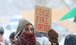 A participant holds a sign directed at the US Consulate General building on University Ave...