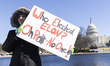A protester holds a sign during the rally against the Donald Trump administration during '...