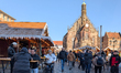 Locals and tourists experience a warm sunny winter day in the old city of Nuremberg, Middl...